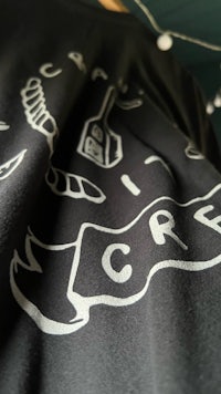 a black t - shirt with a white design on it