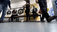 a group of people standing in front of a washing machine