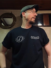 a man wearing a black t - shirt and hat